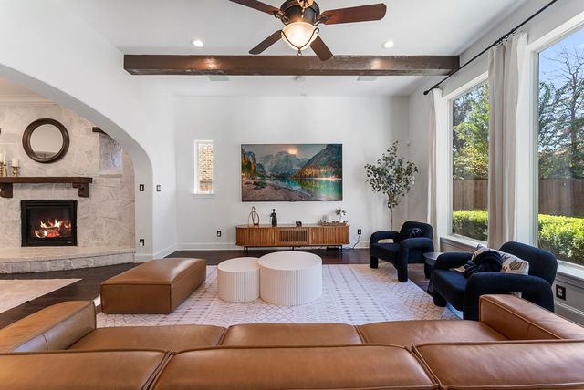 a living room with furniture a large window and a fireplace