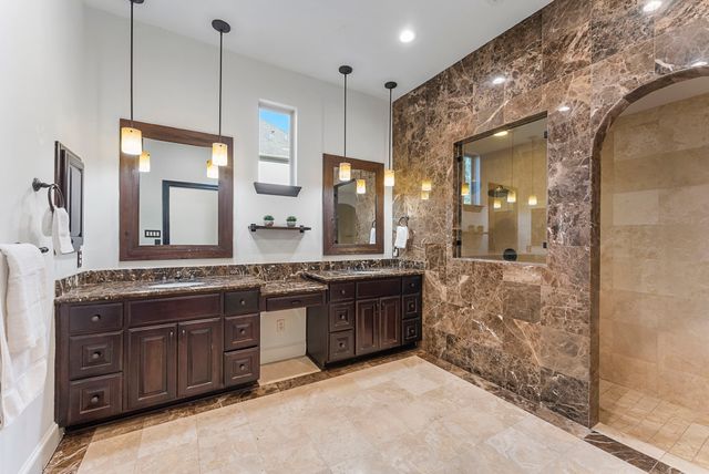 a bathroom with a granite countertop double vanity sink and a mirror