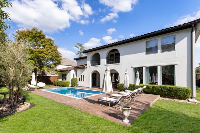 a view of a white house with a big yard and large trees