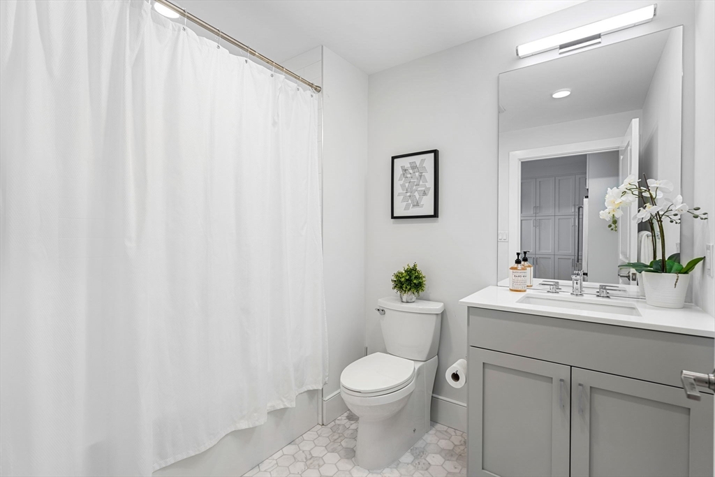 30 Polk Street, Unit 208 Boston, MA 02129 - Photo 11 of 30 a bathroom with a toilet a sink and a mirror