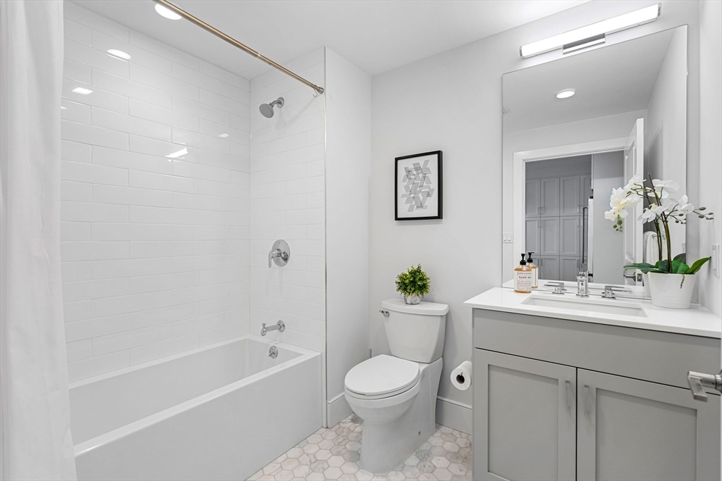 30 Polk Street, Unit 208 Boston, MA 02129 - Photo 12 of 30 a bathroom with a toilet a bath tub a sink and mirror