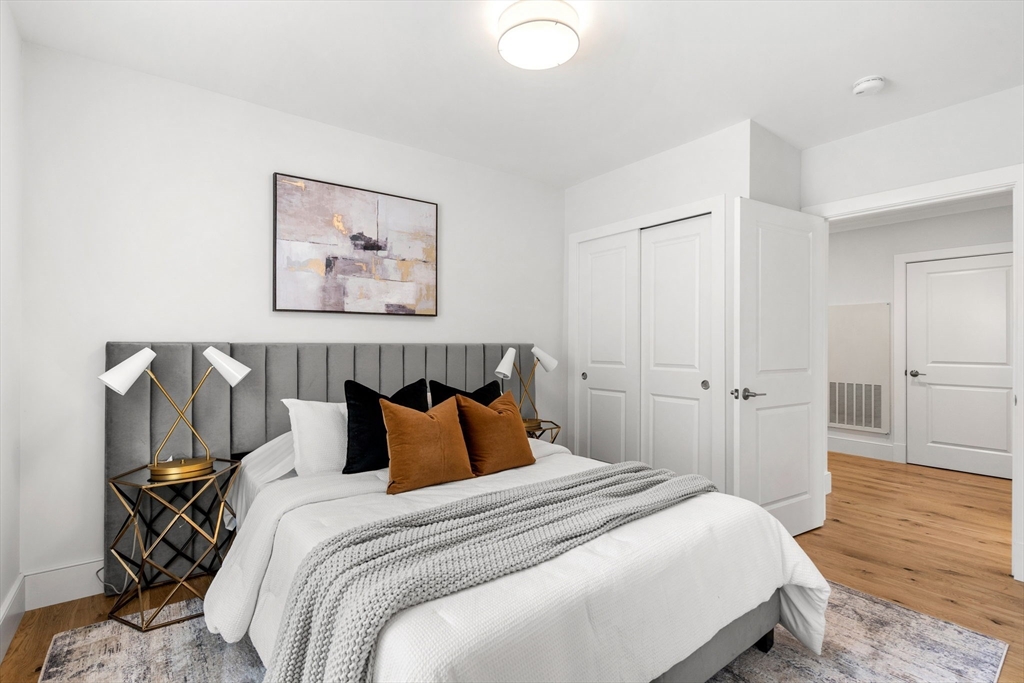 30 Polk Street, Unit 208 Boston, MA 02129 - Photo 14 of 30 a bedroom with a bed and wooden floor