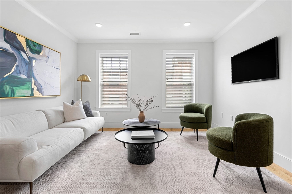 30 Polk Street, Unit 208 Boston, MA 02129 - Photo 2 of 30 a living room with furniture a flat screen tv and a large window