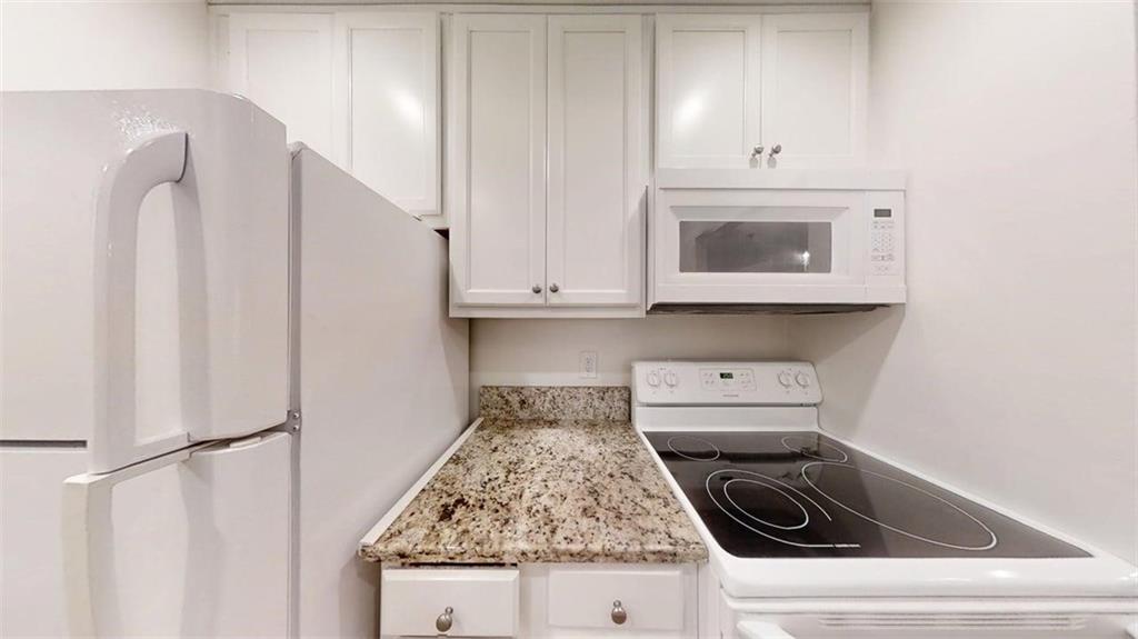 300 Johnson Ferry Road, Unit A112 Atlanta, GA 30328 - Photo 12 of 42 a kitchen with white cabinets and white appliances