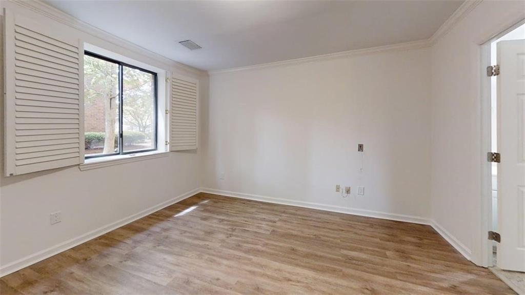 300 Johnson Ferry Road, Unit A112 Atlanta, GA 30328 - Photo 29 of 42 a view of an empty room with wooden floor and a window