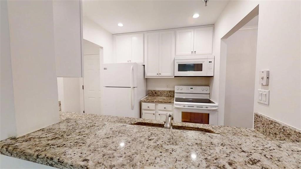 300 Johnson Ferry Road, Unit A112 Atlanta, GA 30328 - Photo 7 of 42 a kitchen with a stove and a refrigerator