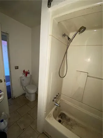 a bathroom with a granite countertop toilet a sink and shower