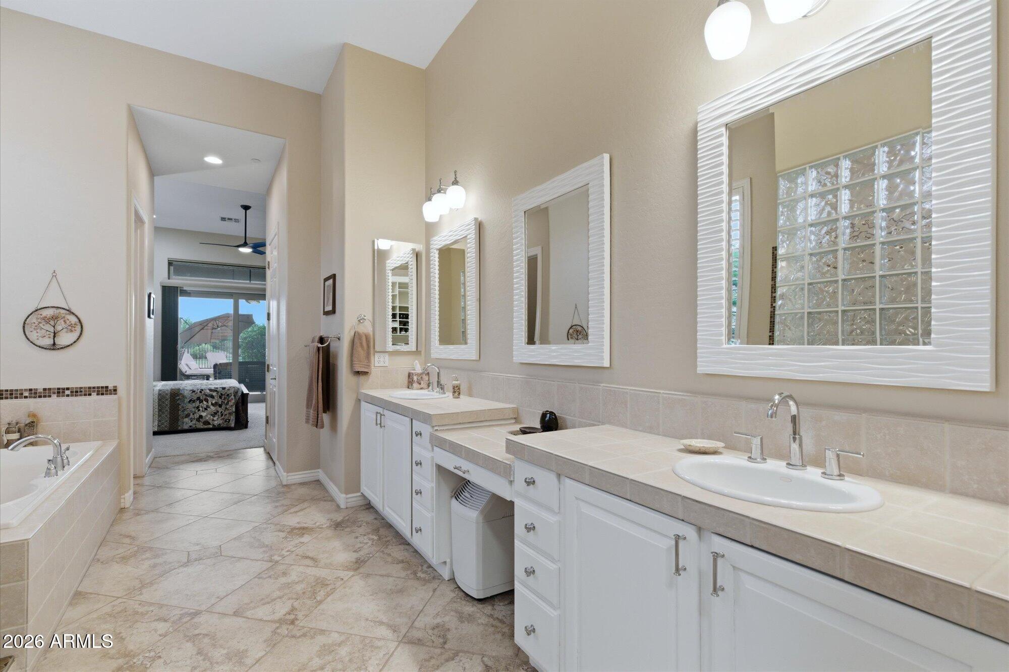 40322 North Hawk Ridge Trail Anthem, AZ 85086 - Photo 30 of 63 a large bathroom with a double vanity sink large mirror and shower