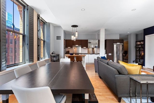 a living room with fireplace furniture and a large window