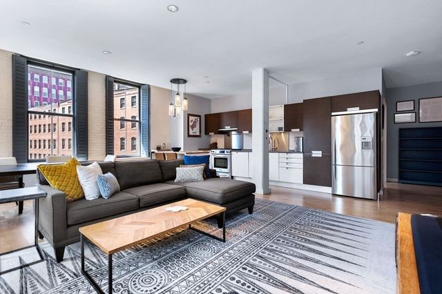 a living room with furniture and large windows