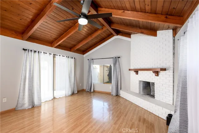 a view of a livingroom with wooden floor and a fireplace