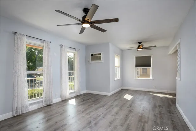 a view of a livingroom with a ceiling fan window and wooden floor