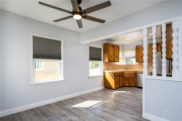 a view of an empty room with window and wooden floor