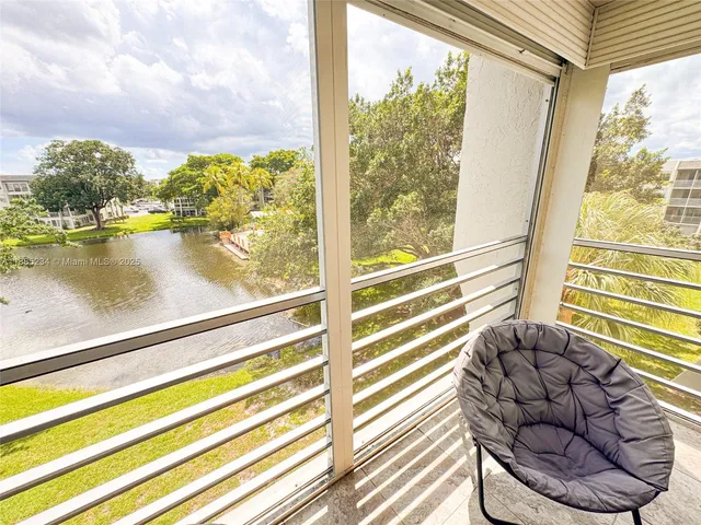 a view of a balcony with floor to ceiling windows with wooden floor