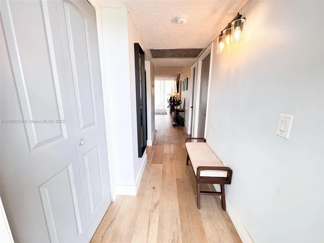 a hallway with wooden floor fireplace and living room