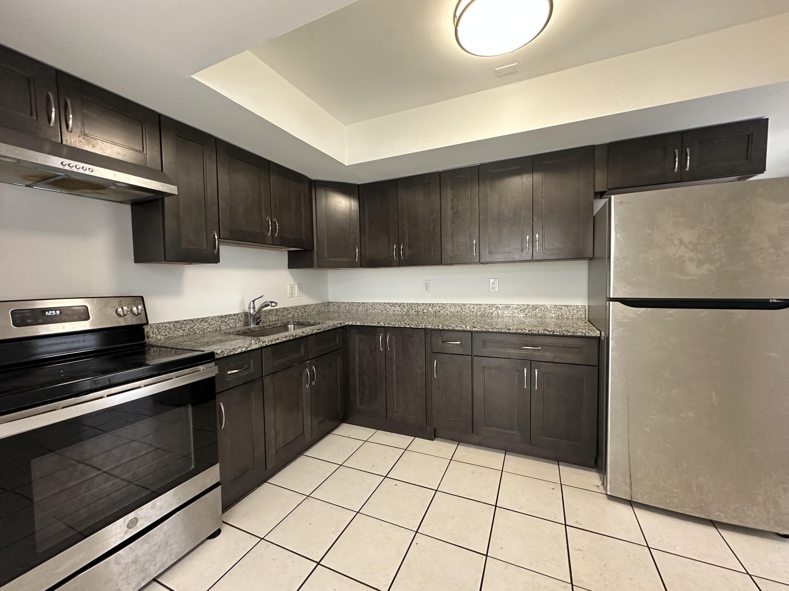 4606 Southeast Binnacle Way, Unit 1 Stuart, FL 34997 - Photo 2 of 5 a kitchen with a sink a stove and refrigerator