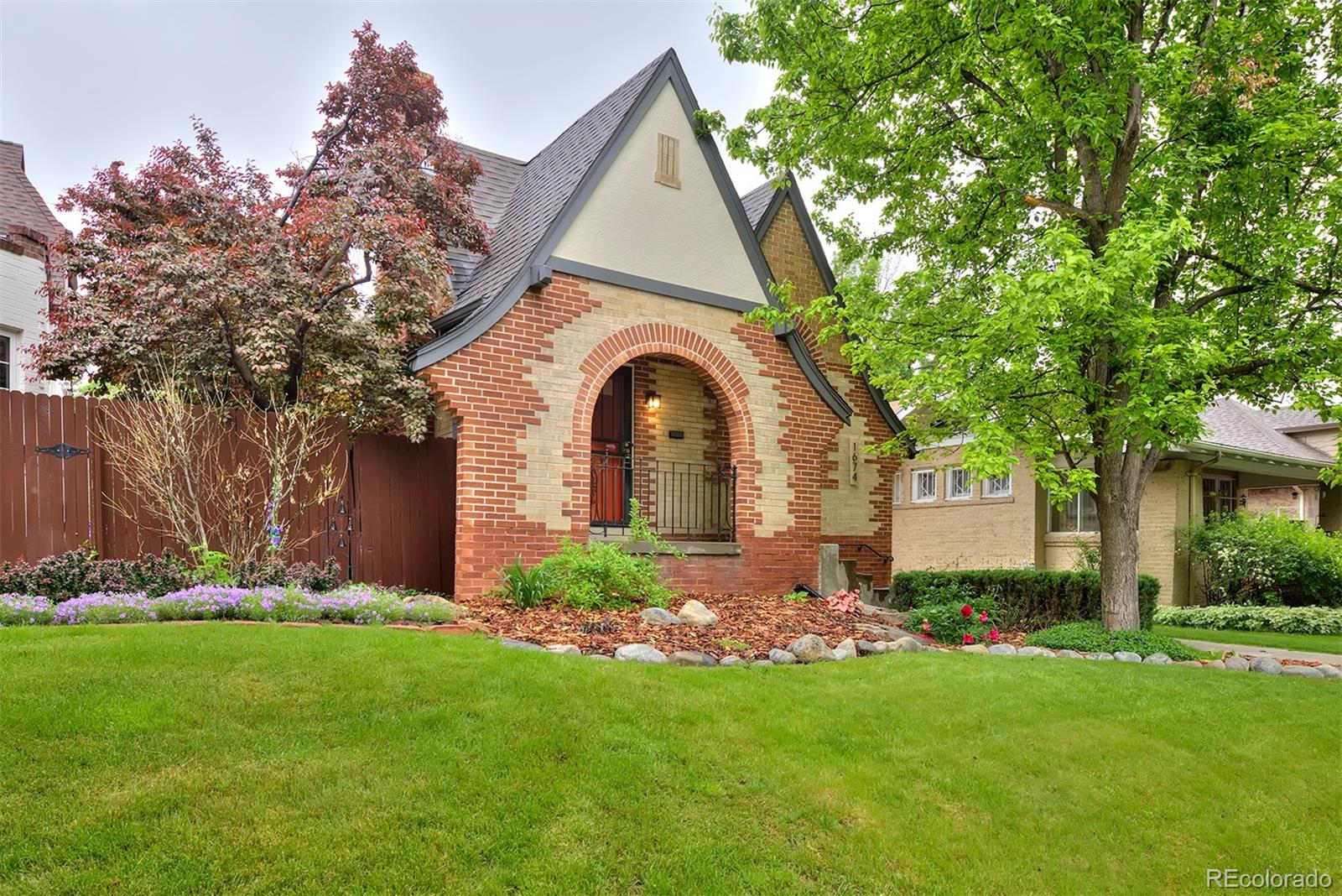 a front view of a house with a garden and plants