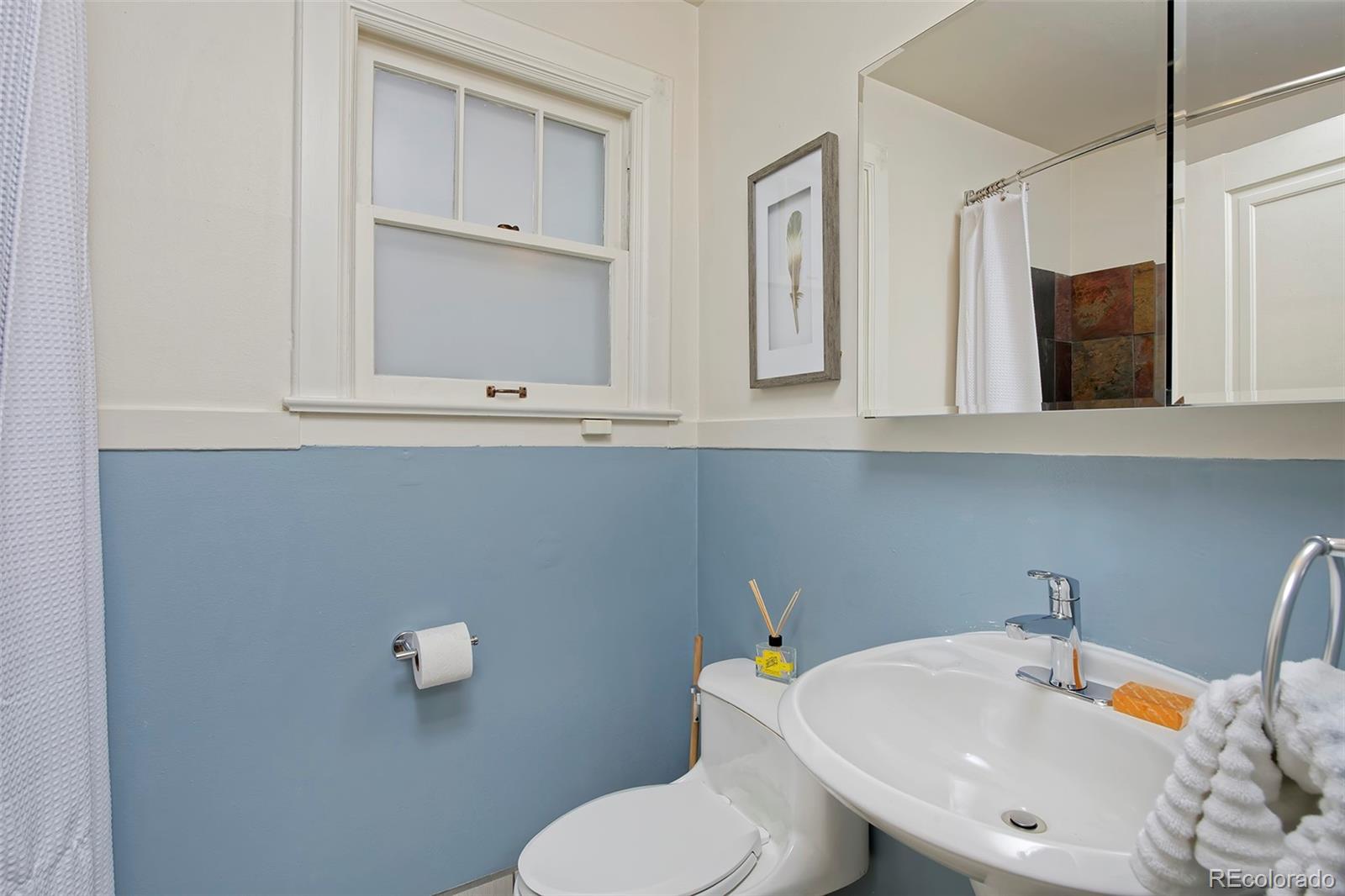 1674 Cherry Street Denver, CO 80220 - Photo 12 of 31 a bathroom with a toilet sink and mirror