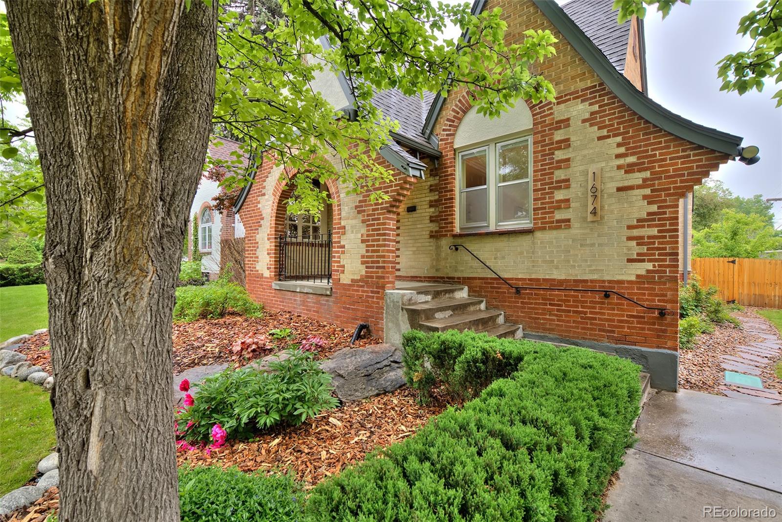 1674 Cherry Street Denver, CO 80220 - Photo 2 of 31 a front view of a house with a garden