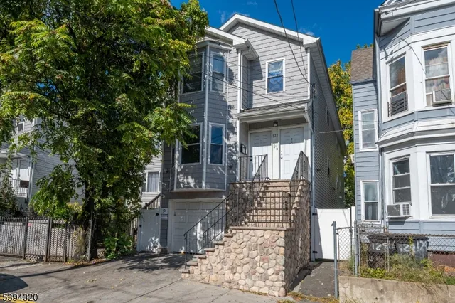 a front view of a building with a tree