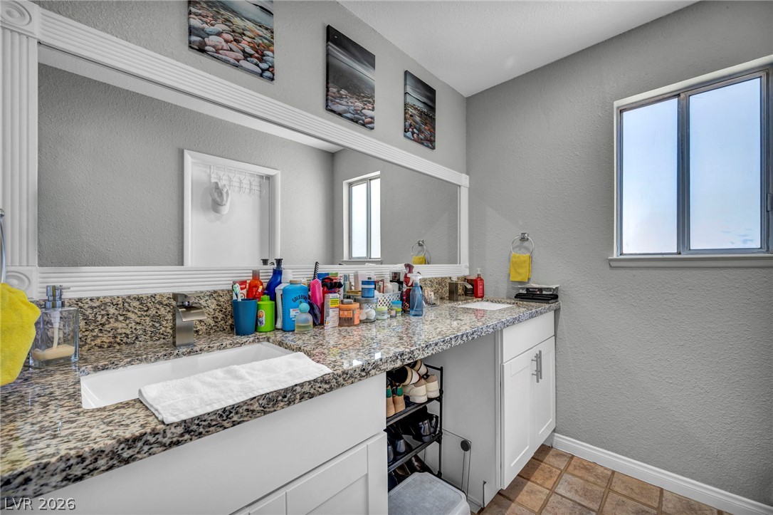 5882 Rio Tinto Way Las Vegas, NV 89110 - Photo 13 of 56 Double vanity with stone counters provides ample space and functionality in this well-appointed bathroom.