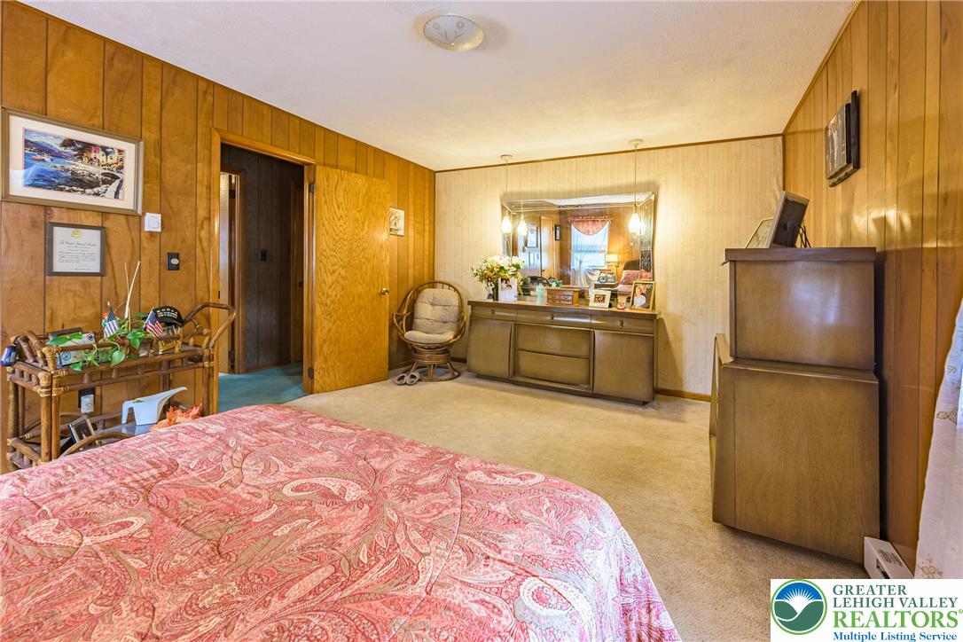 678 Interchange Road Kresgeville, PA 18333 - Photo 27 of 45 A well-lit bedroom features warm wood paneling, plush carpet, and ample space for furnishings.