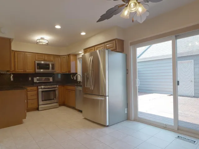 a kitchen with stainless steel appliances granite countertop a refrigerator and a stove top oven