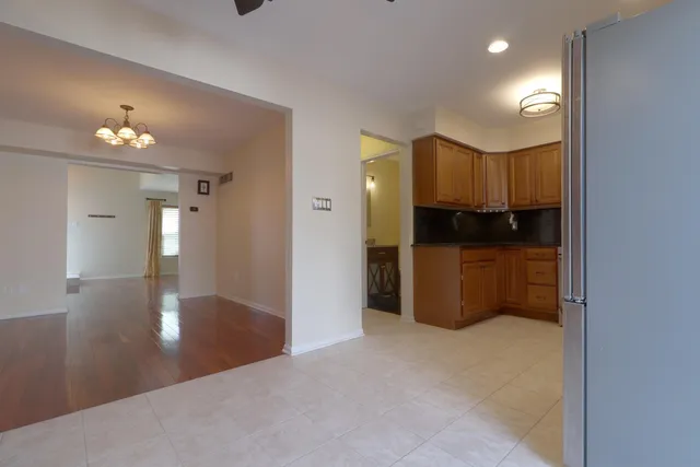 a view of an empty room and a kitchen