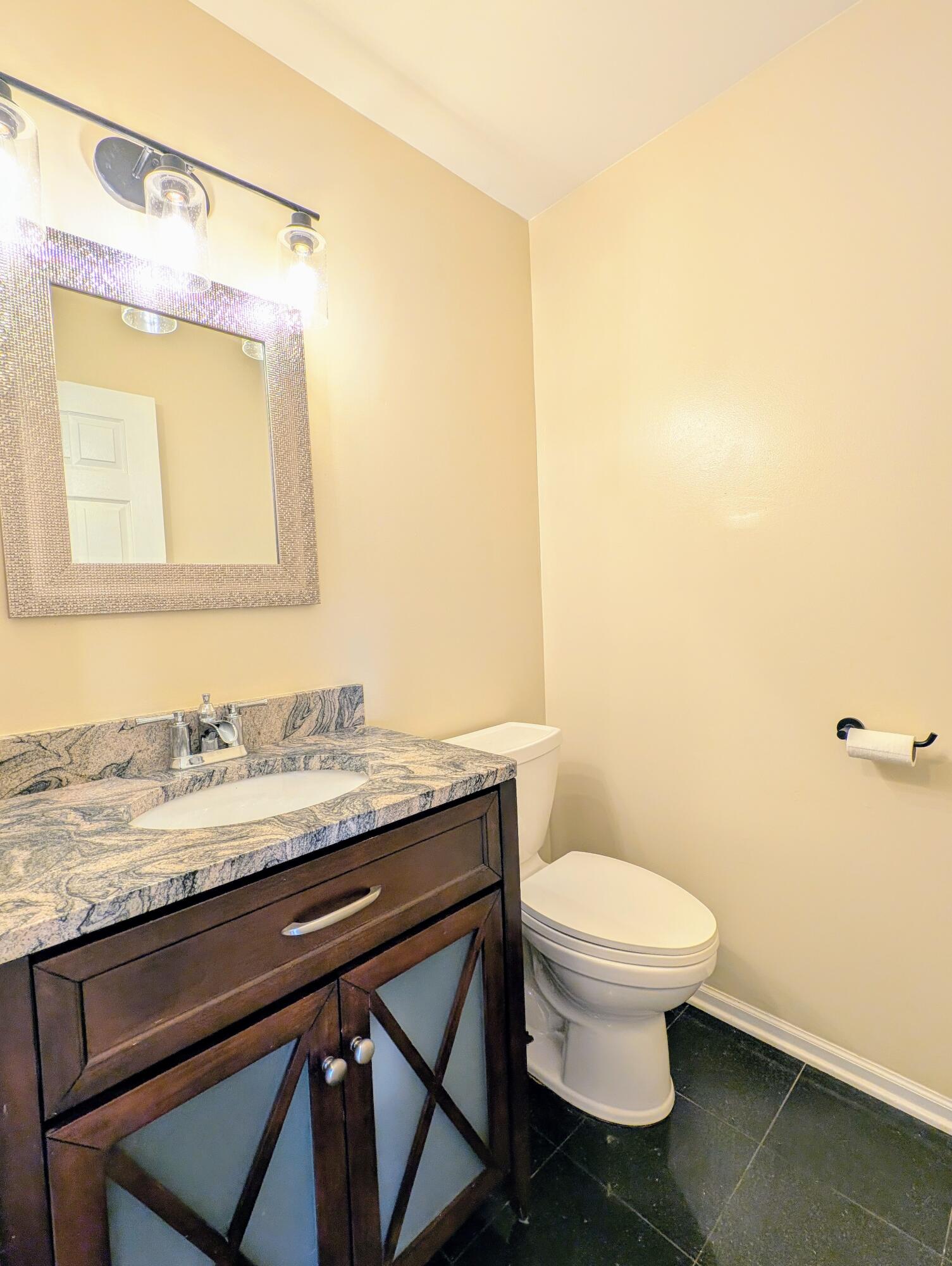 767 Kenmare Parkway Crown Point, IN 46307 - Photo 9 of 27 a bathroom with a granite countertop sink a toilet and a mirror