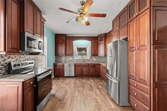 a kitchen with stainless steel appliances granite countertop a refrigerator and a sink
