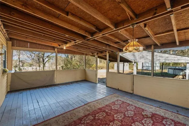 a view of an empty room with wooden floor and a rug