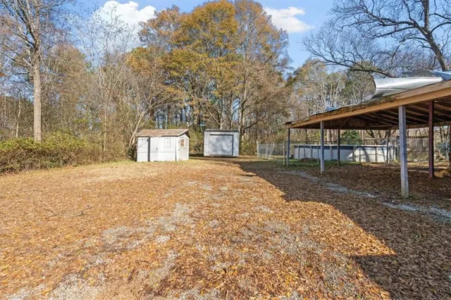 a view of a white house with a yard and large tree