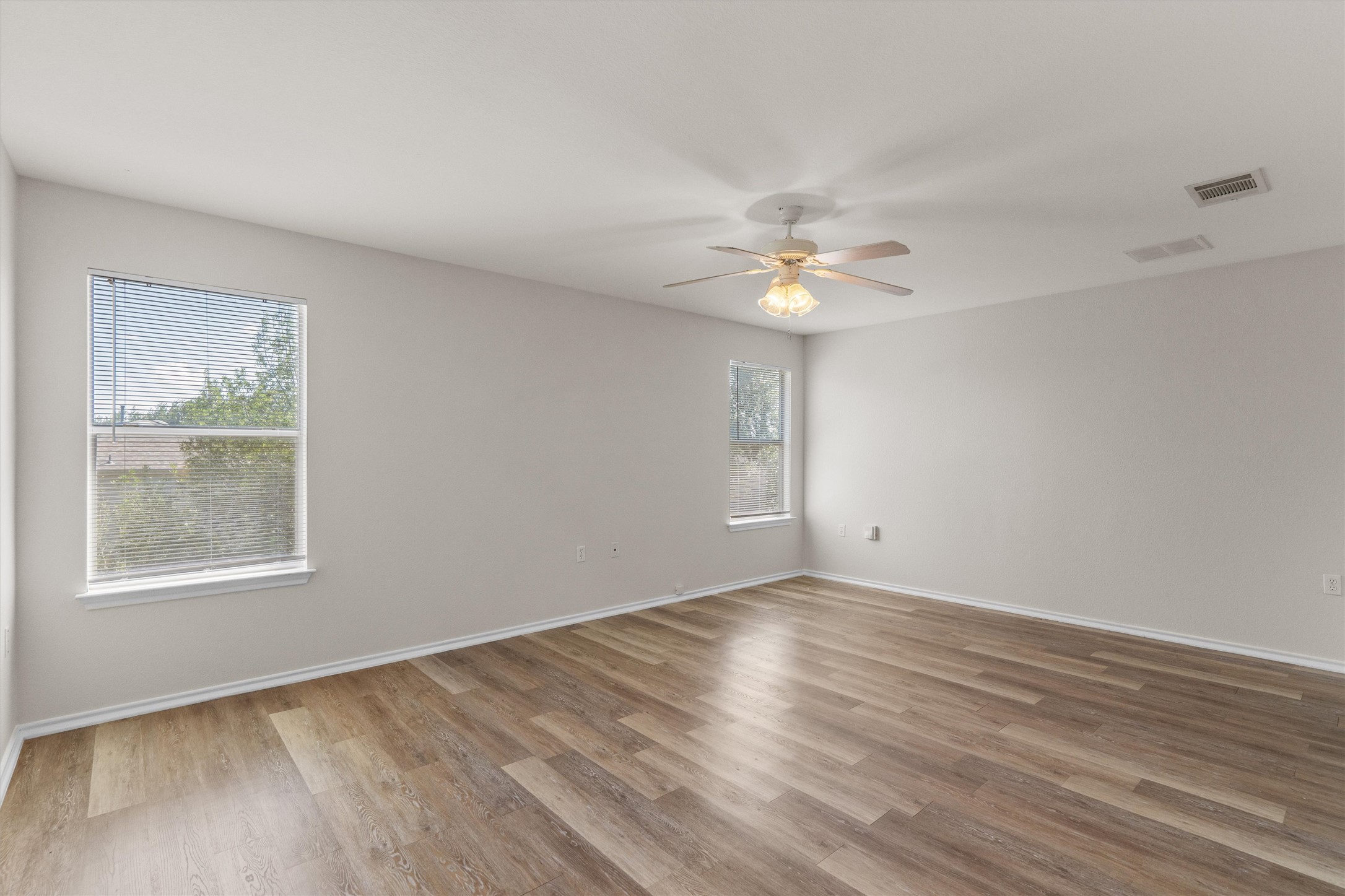 5825 Silver Screen Drive Austin, TX 78747 - Photo 15 of 40 Natural light floods this room, highlighting the warm, wide-plank flooring and clean, minimalist walls.