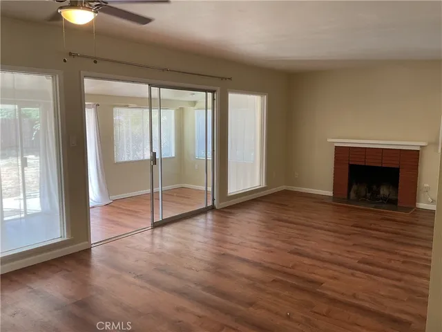 wooden floor fireplace and windows in an empty room