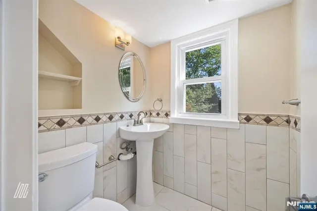 a bathroom with a sink and mirror with toilet
