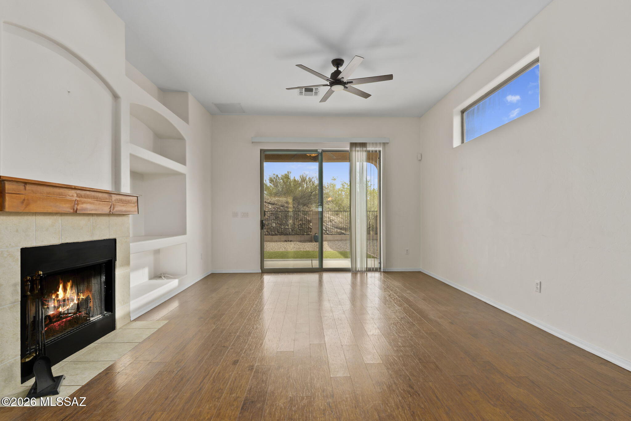 13668 East High Plains Ranch Street Vail, AZ 85641 - Photo 18 of 51 a view of an empty room with wooden floor fireplace and a window