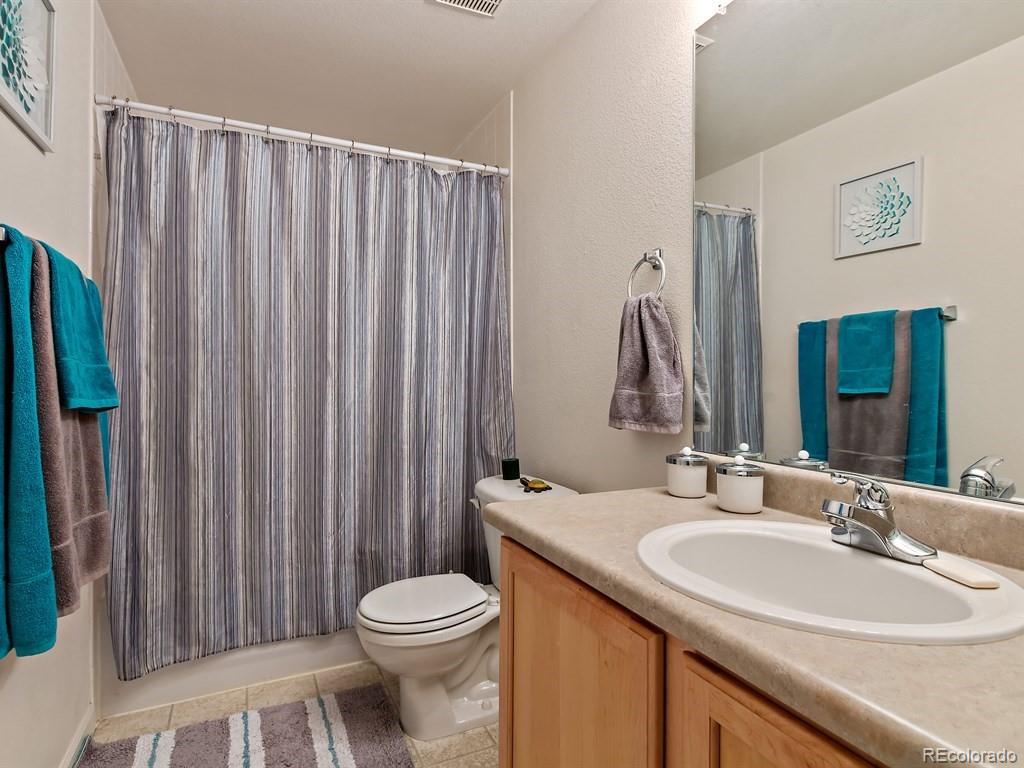 5800 Tower Road, Unit 908 Denver, CO 80249 - Photo 17 of 25 a bathroom with a sink a toilet and shower curtain