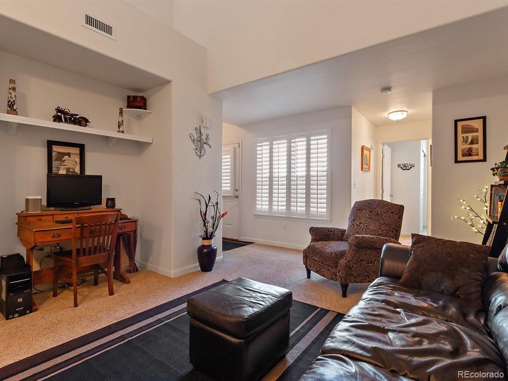 5800 Tower Road, Unit 908 Denver, CO 80249 - Photo 4 of 25 a living room with furniture and wooden floor