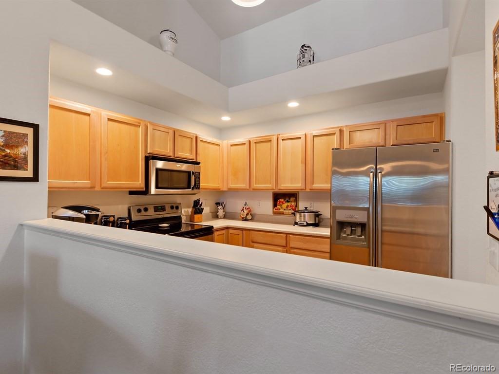 5800 Tower Road, Unit 908 Denver, CO 80249 - Photo 5 of 25 a kitchen with stainless steel appliances a refrigerator sink and microwave