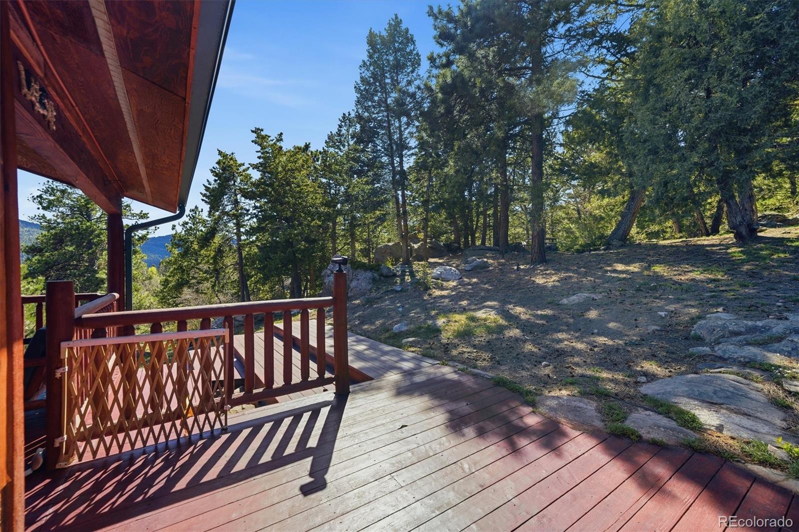 8969 South Hillview Road Morrison, CO 80465 - Photo 34 of 50 a view of a wooden deck with trees