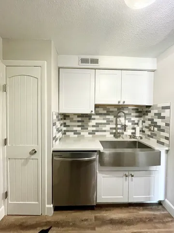 a kitchen with kitchen island granite countertop a sink cabinets and stainless steel appliances