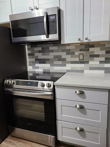 a kitchen with a stove and white cabinets