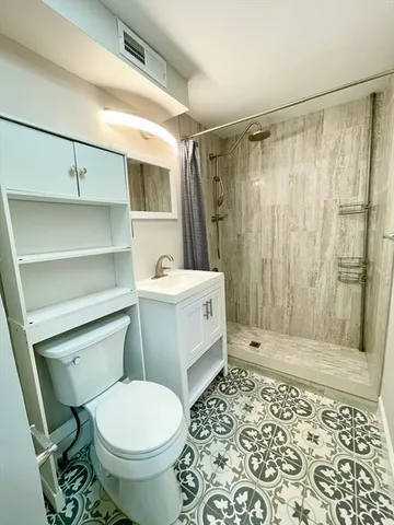 a bathroom with a toilet a sink and shower
