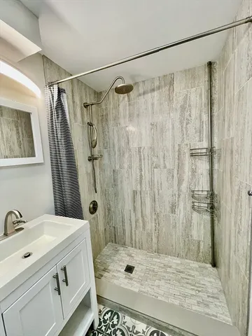a bathroom with a shower curtain a sink and a mirror