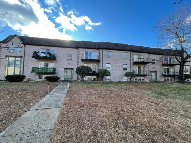 a front view of a house with a yard and potted plants
