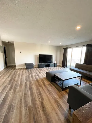 a spacious bedroom with a bed and a flat screen tv