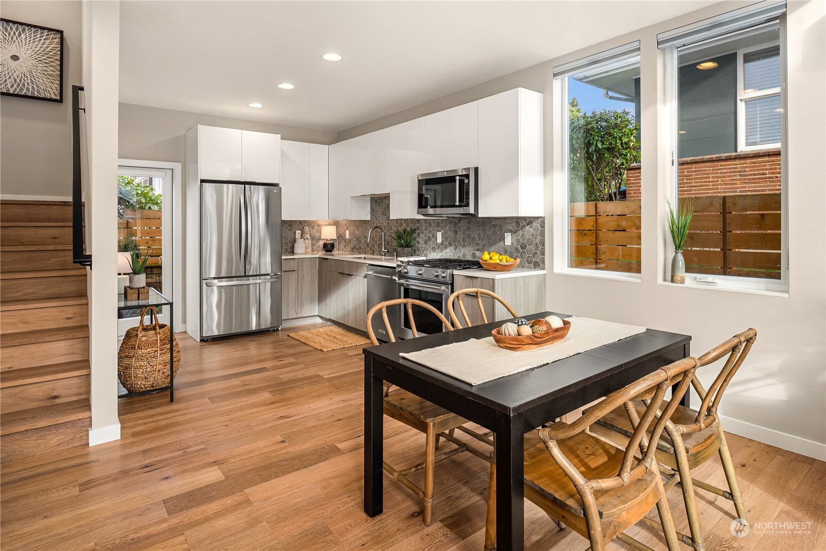 4406 Southwest Holly Street Seattle, WA 98136 - Photo 8 of 32 a kitchen with stainless steel appliances granite countertop a stove top oven a refrigerator a sink and a dining table with wooden floor