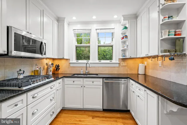 a bathroom with a granite countertop sink mirror vanity and toilet