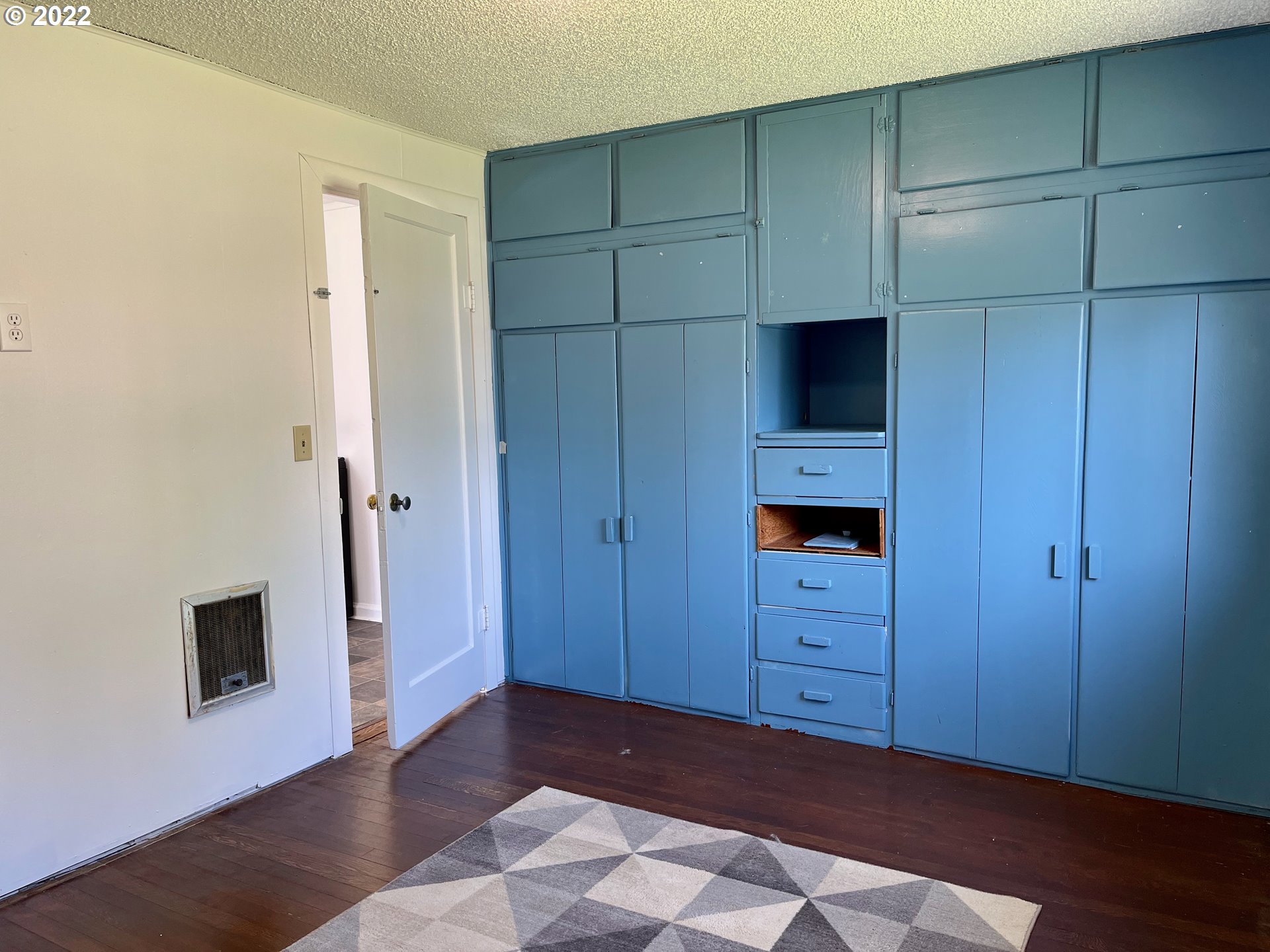 1147 F Street Springfield, OR 97477 - Photo 13 of 32 a view of an empty room with wooden floor and cabinet