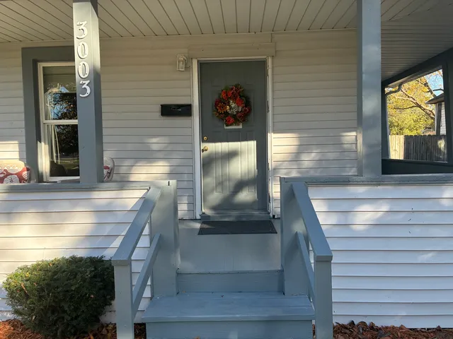a view of a hallway with couch and dining room view
